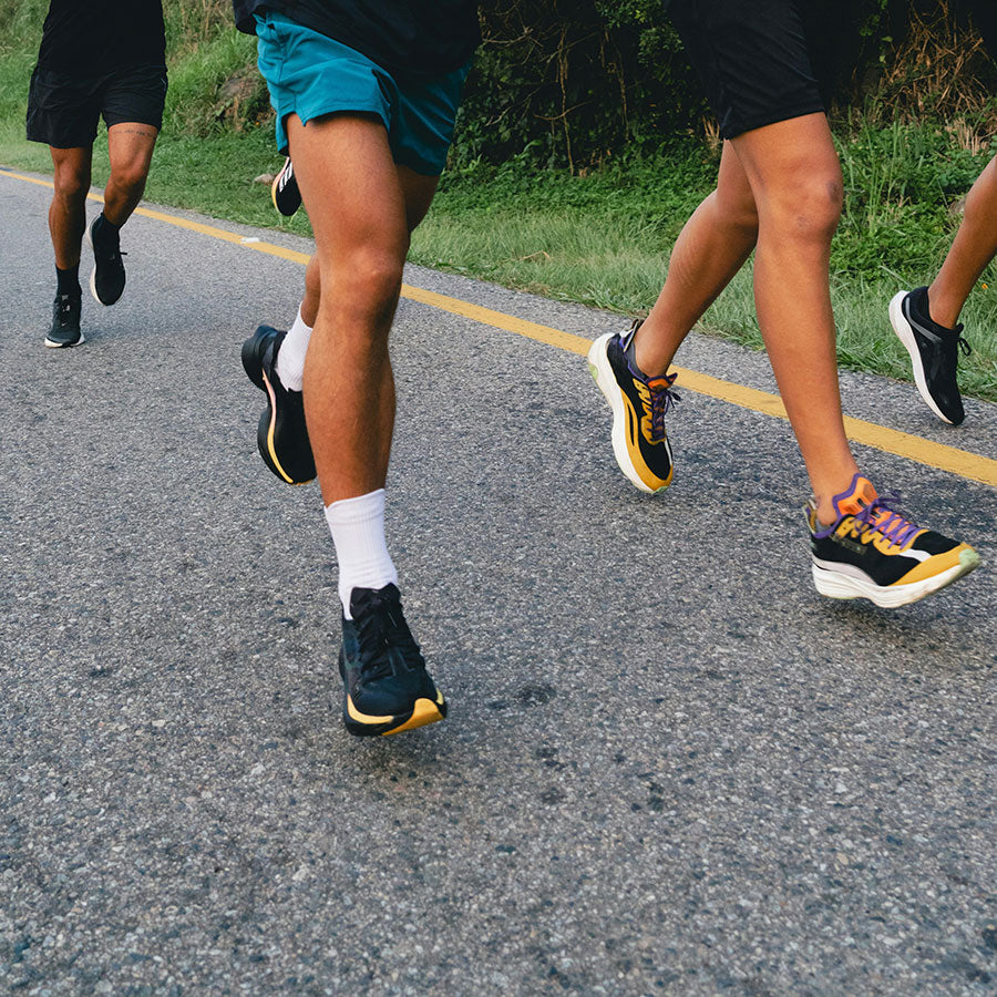 close-up of group of men running along road outside
